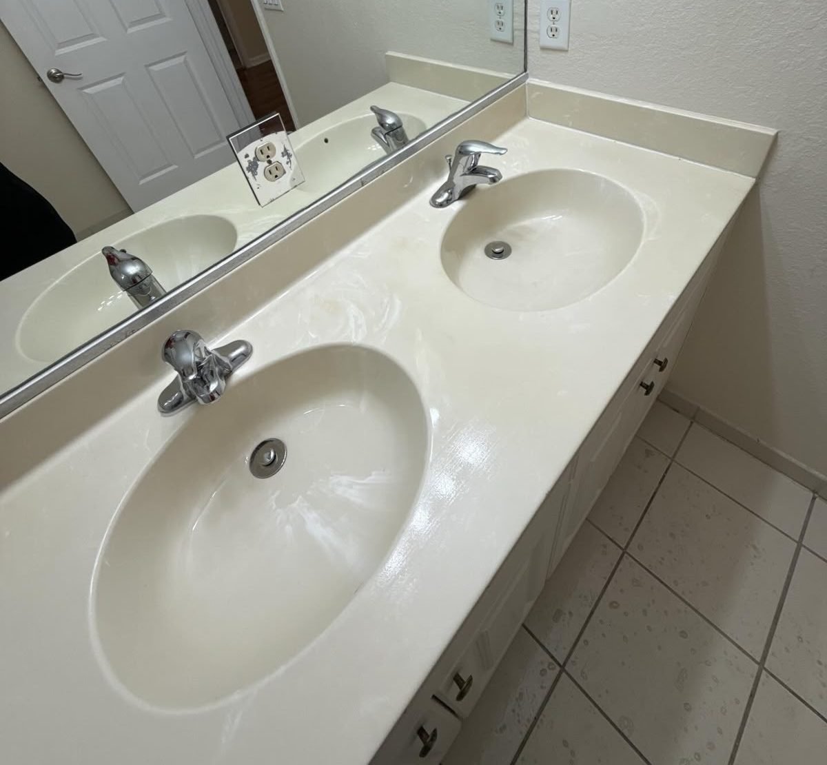 Cleaned double bathroom vanity with two oval basins, chrome faucets and a wall mirror with no streaks